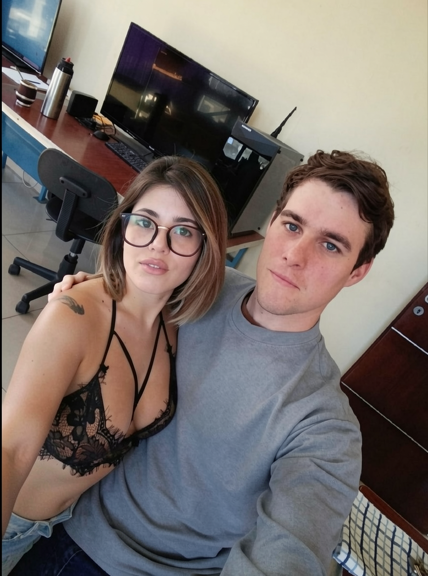Añade a la chica de la imagen de referencia junto al chico. Manten los mismos rasgos faciales e imperfecciones.