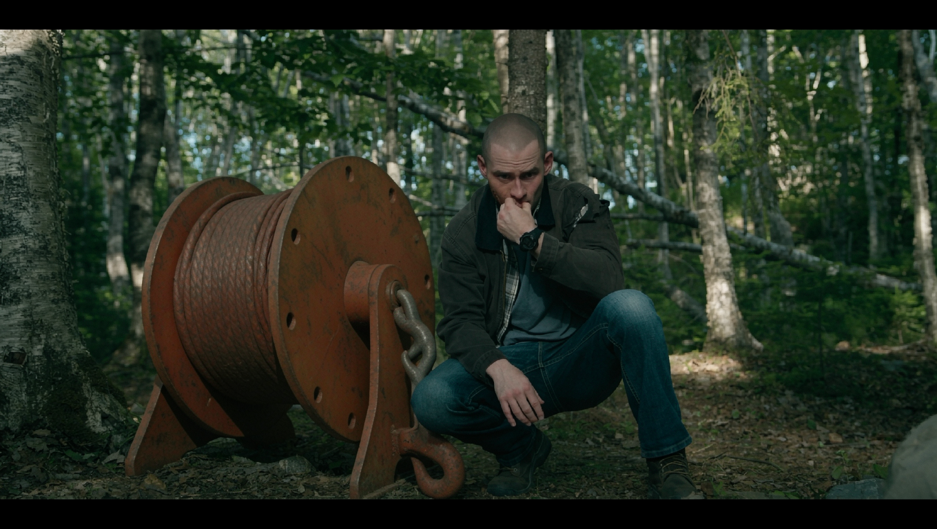 there's a giant winch with a hook next to him